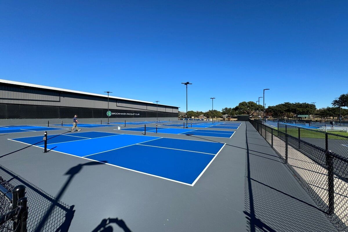 Rows of blue pickleball playing areas on a grey surround with white lines, from the PPA National Championship venue built by Precision Sports CT